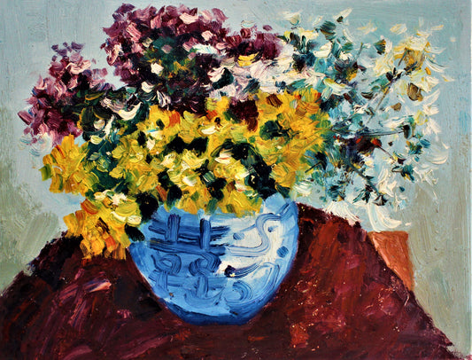 Purple, yellow and white flowers in blue vase