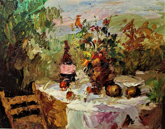 Outdoor table with wine, fruit and flowers