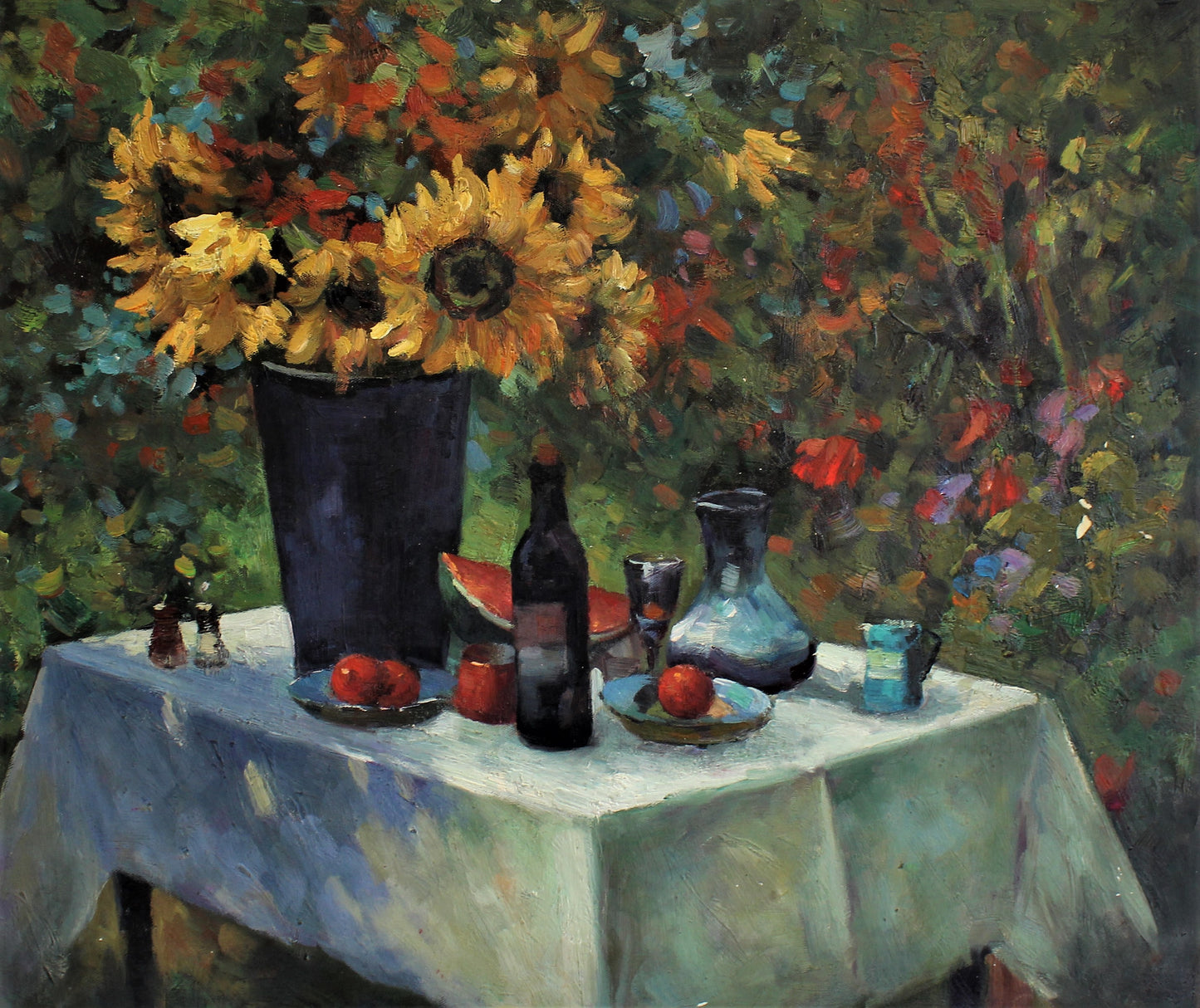 Nature morte de tournesols, de pastèque et de bouteilles sur une table à l'extérieur