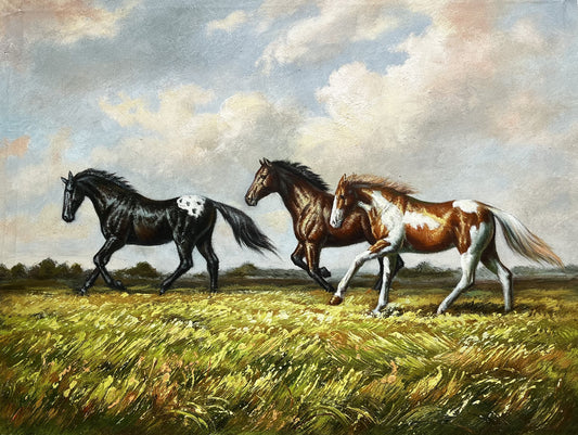 Three horses running in a field